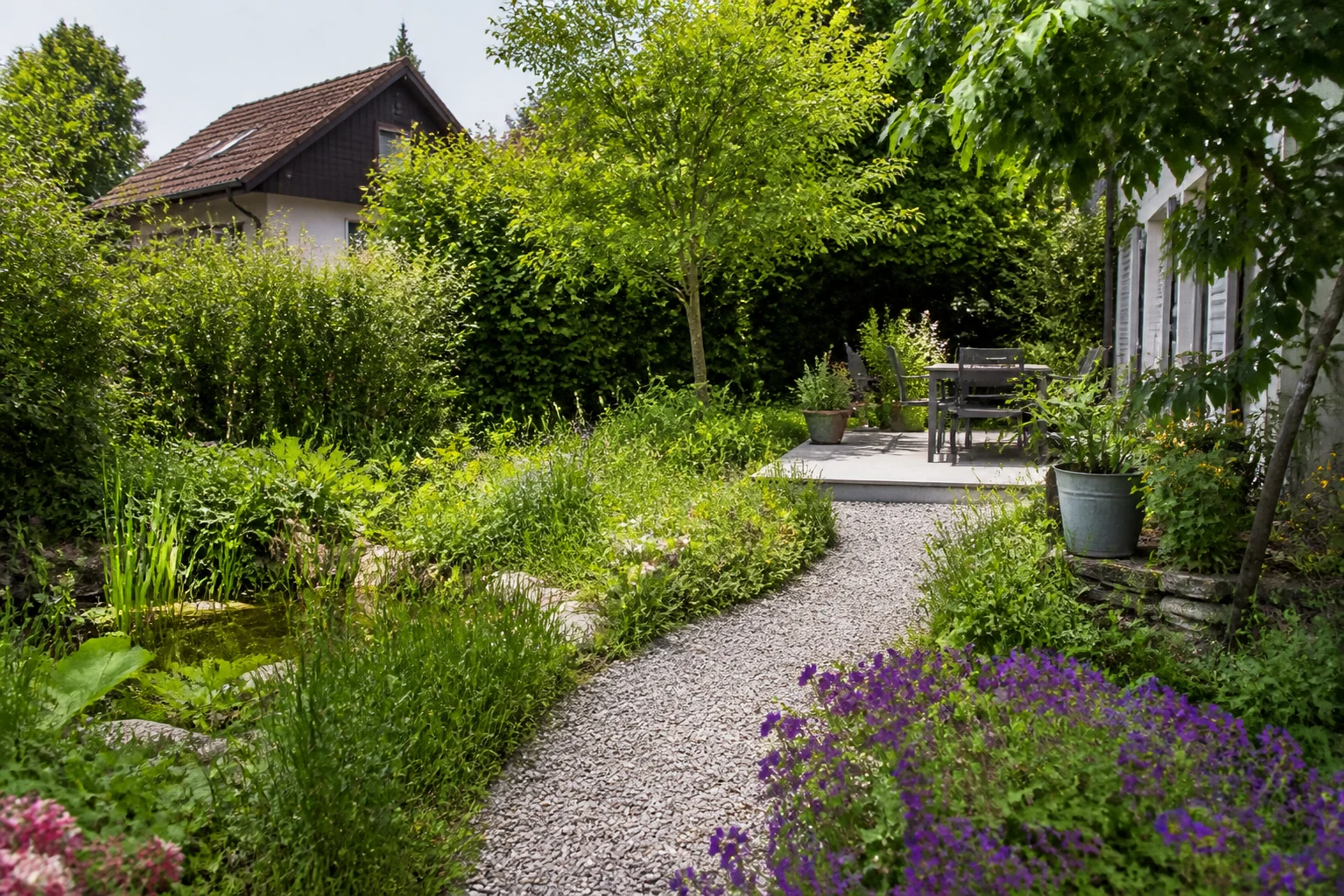 Jardin partiellement réorganisé avec zones de vie et de plantation distinguées